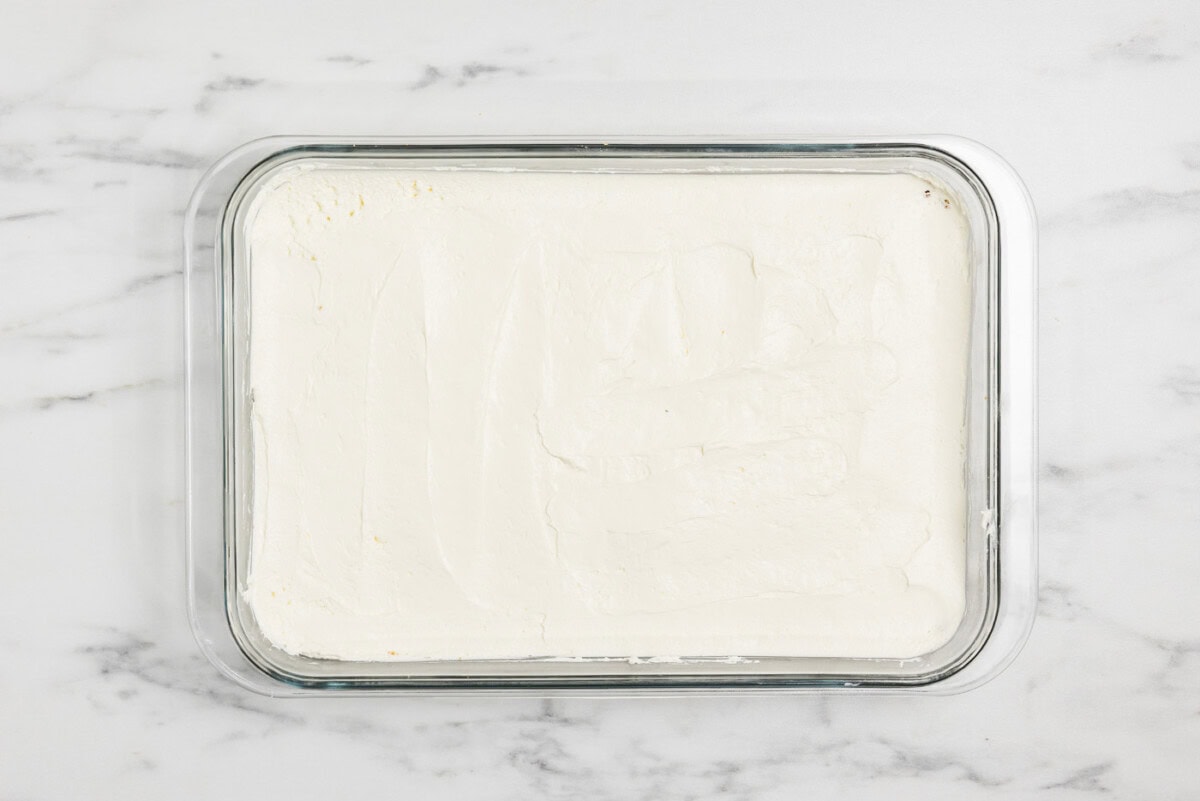 cheesecake layer over graham crust in a baking dish