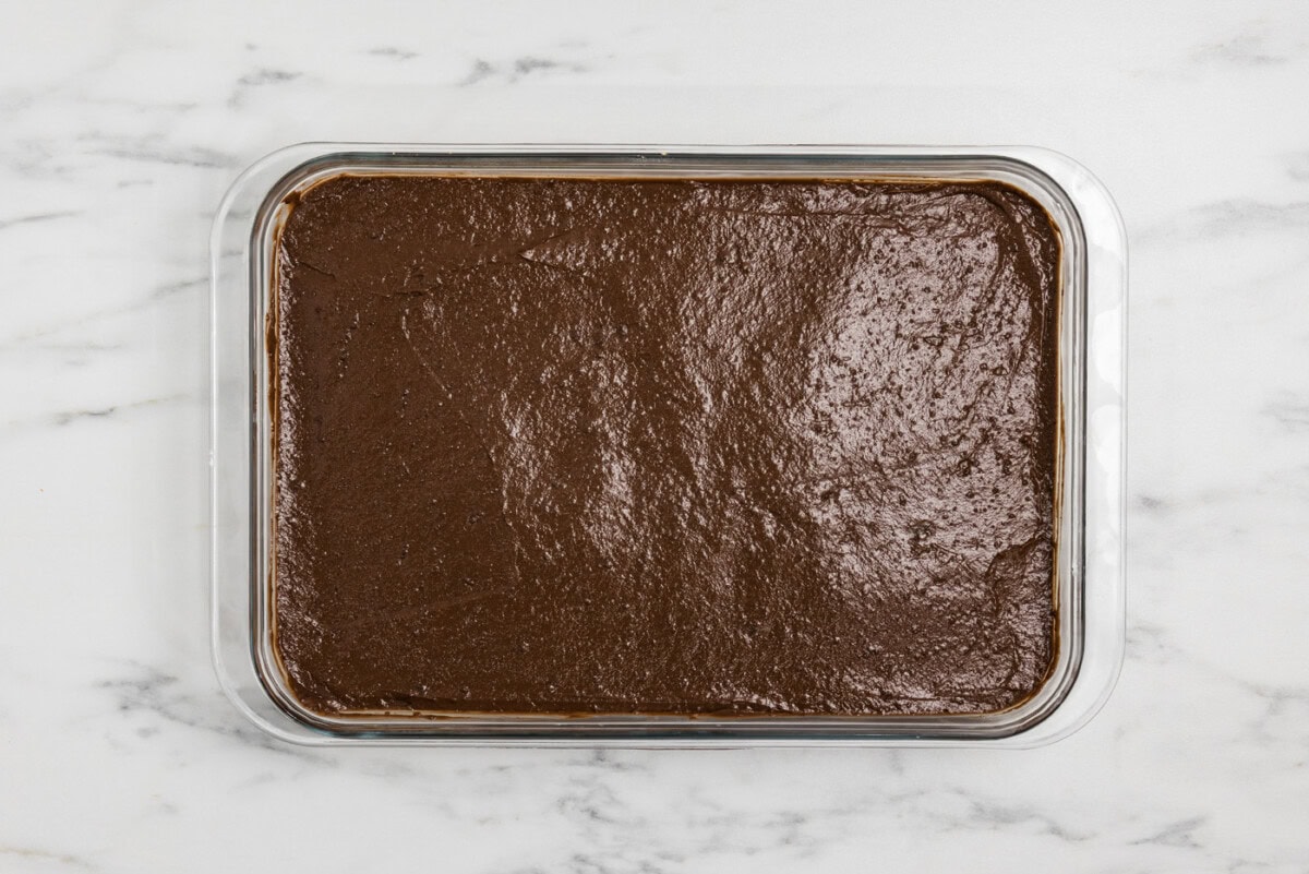 chocolate pudding layer over cheesecake and crust in a baking dish
