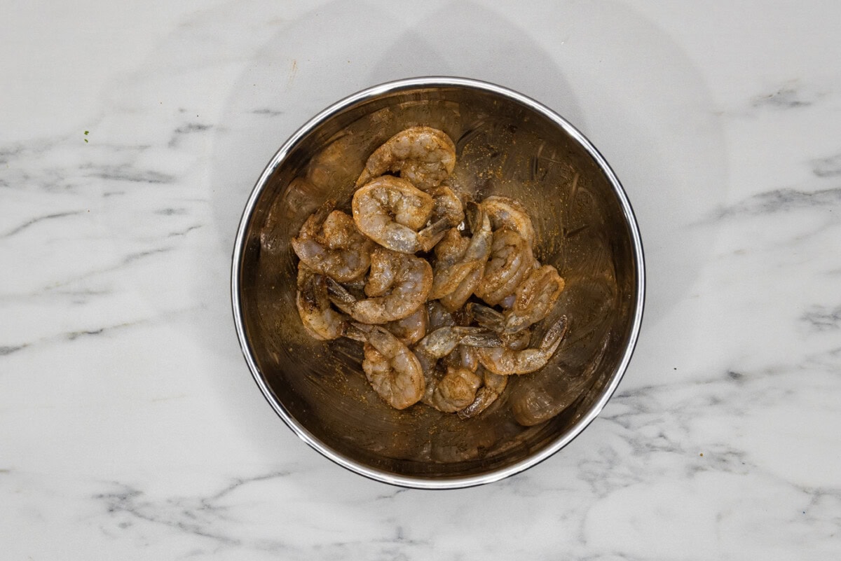raw shrimp in a bowl tossed with oil and seasonings