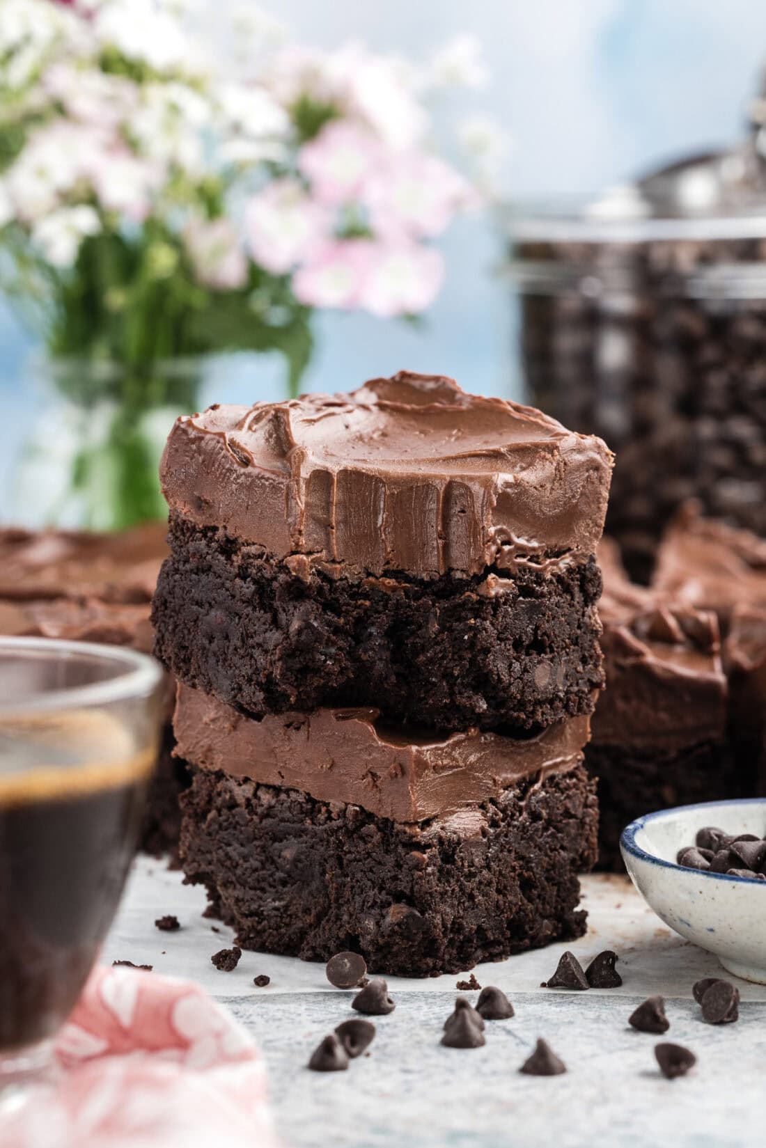 Stack of Fudge Frosted Espresso Brownies with a bite taken out of the top one