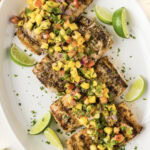 Grilled Mahi Mahi on a white platter with lime wedges
