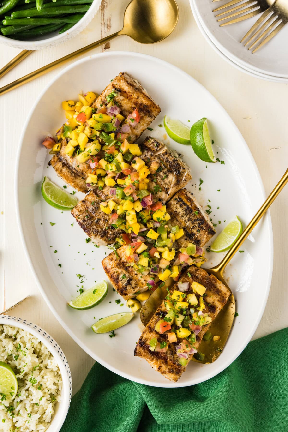 Grilled Mahi Mahi on a white platter with a spatula