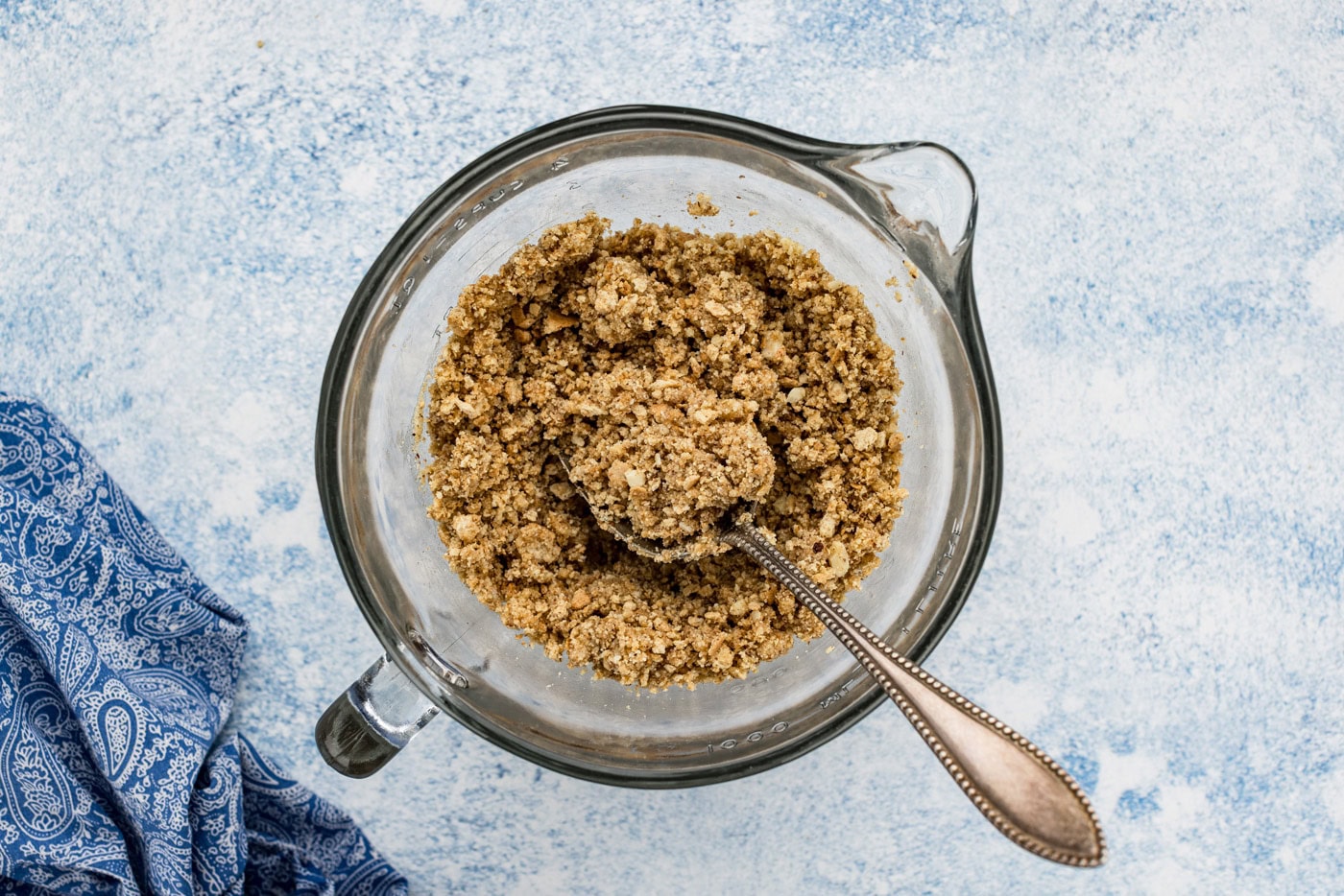 almond and graham cracker mixture in a food processor with a spoon