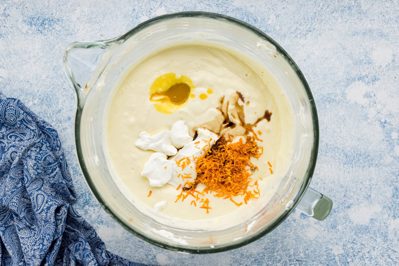 Sour cream, orange juice concentrate, orange zest and vanilla added to cheesecake batter in a bowl