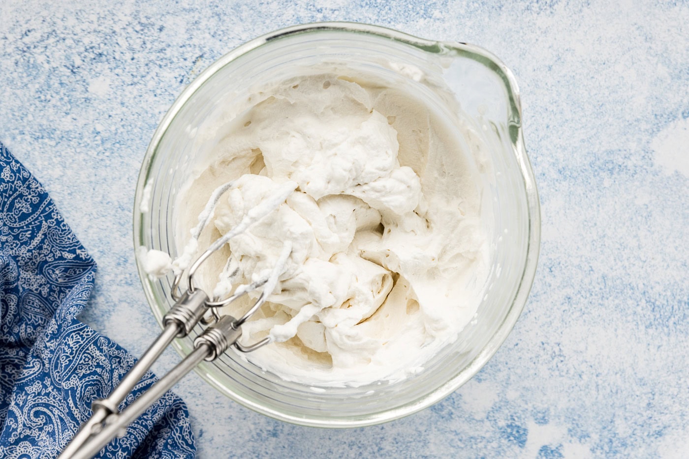Whipped cream in a bowl with mixer attachments