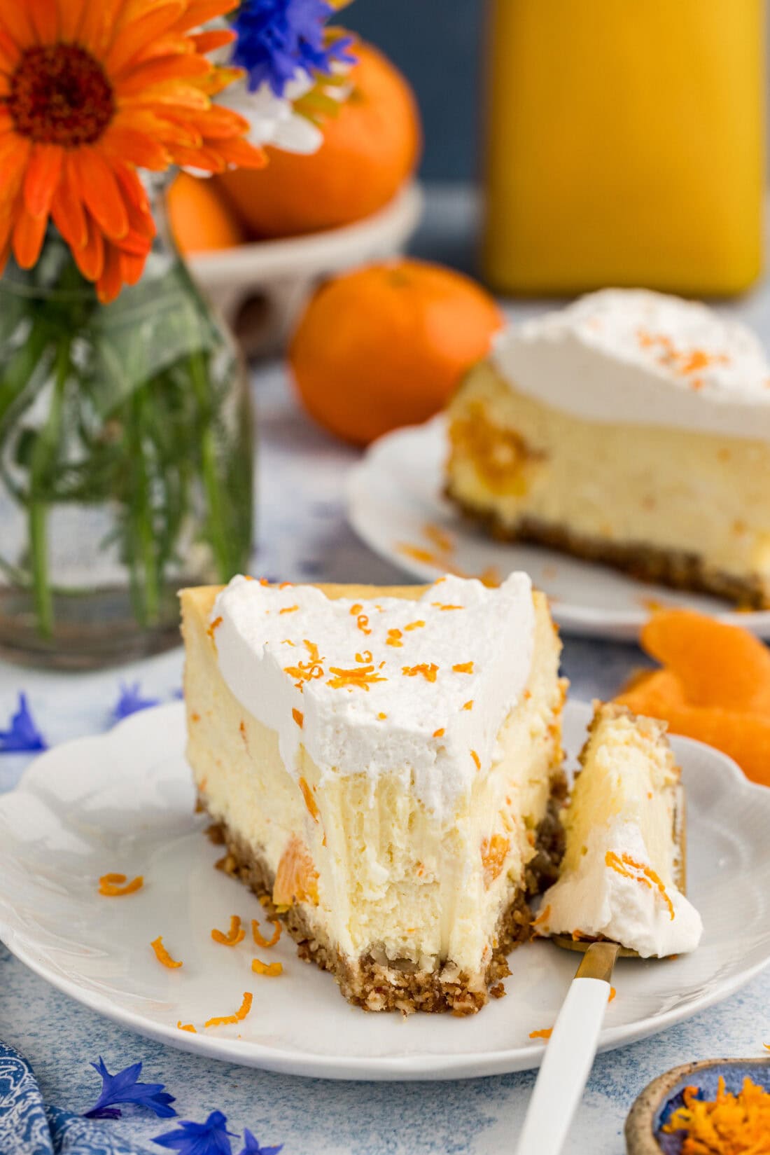 Slice of Mandarin Orange Cheesecake on a plate with a bite removed