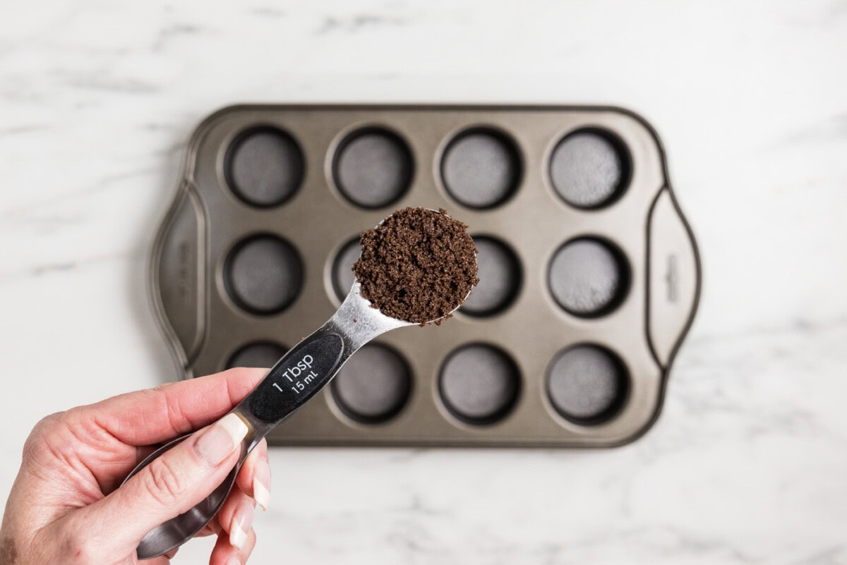 tablespoon of chocolate graham cracker crumbs over mini cheesecake pan