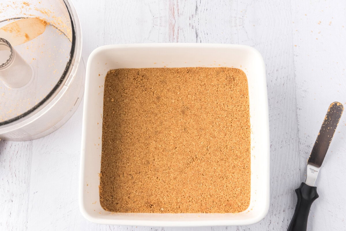 graham cracker crust in a square baking pan