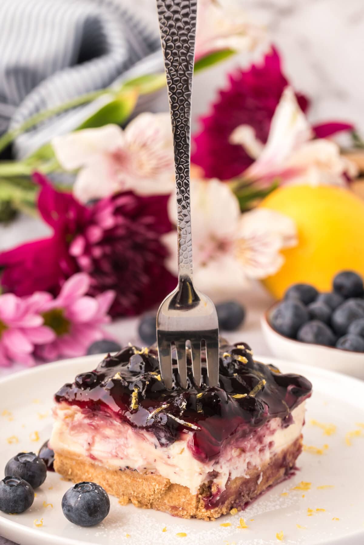 Fork pressing into a slice of No Bake Blueberry Cheesecake