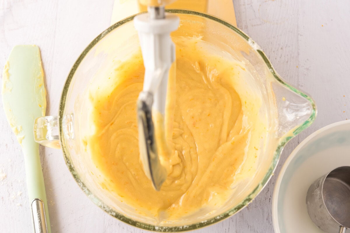 orange cupcake batter in a stand mixer bowl
