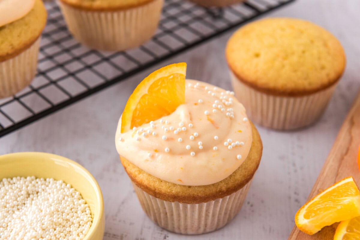 creamsicle cupcakes garnished with orange wedge and sprinkles