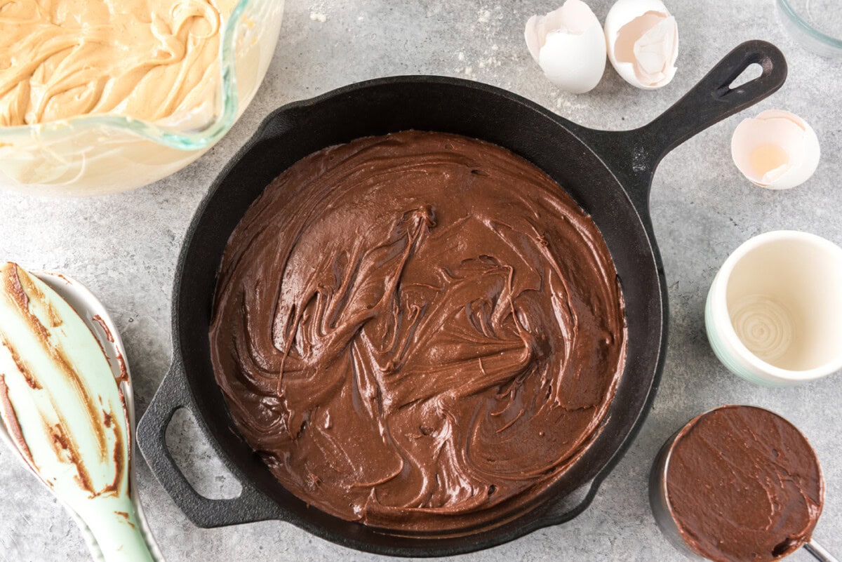 brownie batter added to a cast iron skillet