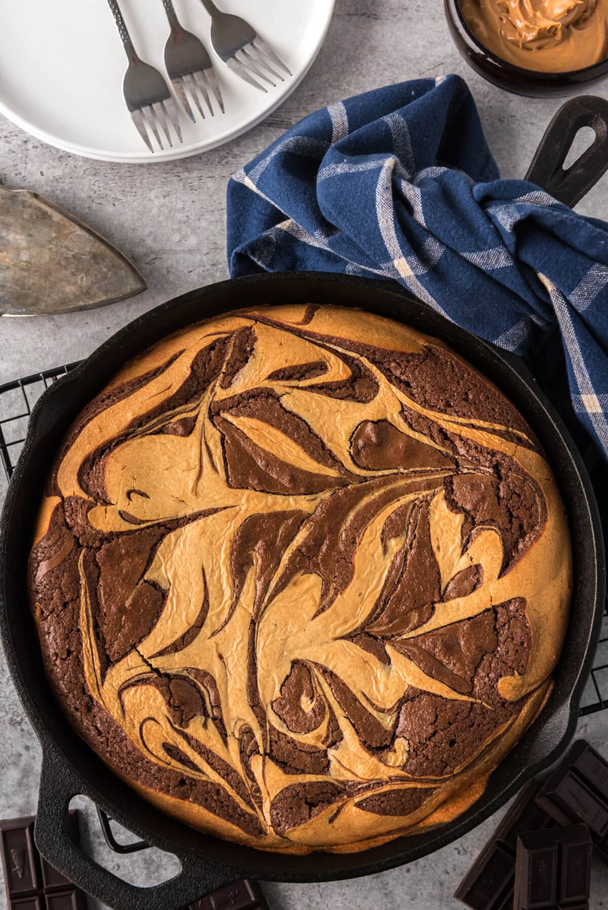 Peanut Butter Marbled Brownie Skillet Pie with plates in the background