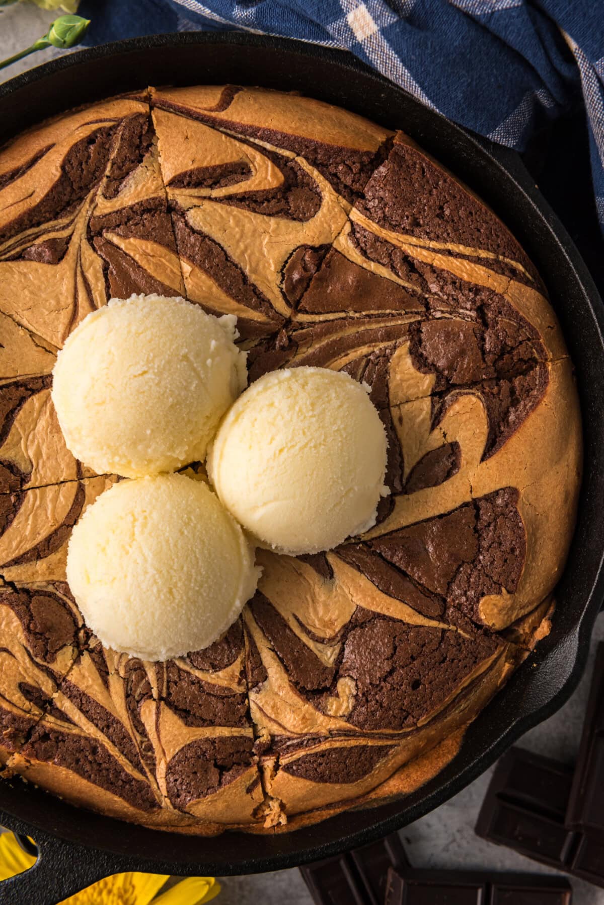 Close up photo of a Peanut Butter Marbled Brownie Skillet Pie topped with three scoops of ice cream