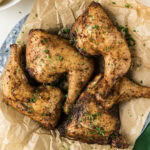 Close up photo of Smoked Chicken Quarters on a parchment lined platter