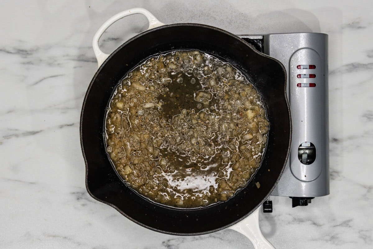 shallots and garlic mixture in a skillet with white wine