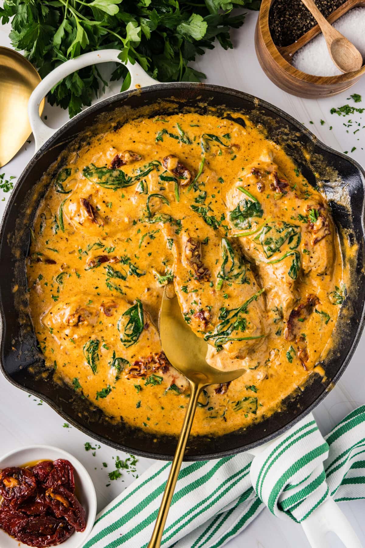Skillet of Tuscan Chicken with a spatula in it