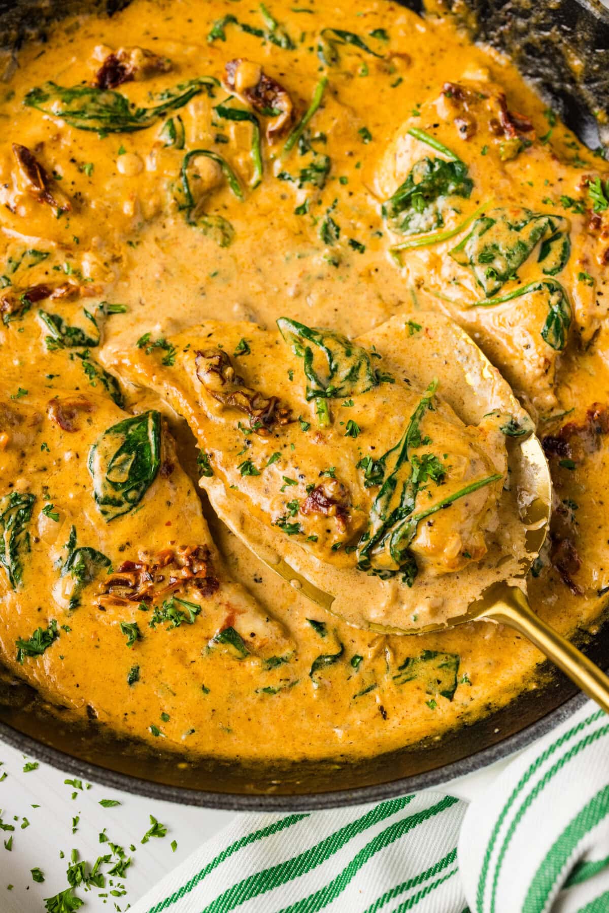 Close up photo of a spatula in a skillet of Tuscan Chicken