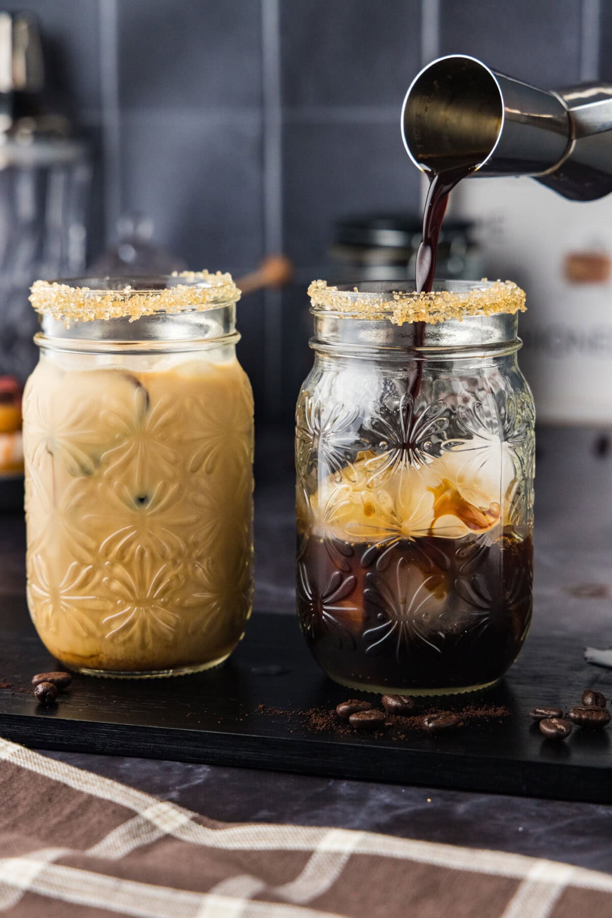 jigger pouring espresso into glass with vodka