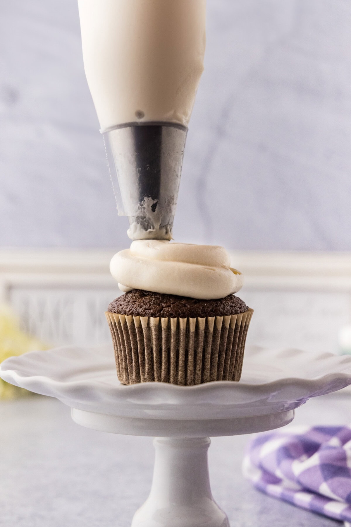 Marshmallow Frosting being piped on a cupcake