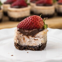 Close up photo of a Mini Strawberry Cheesecake with a bite removed