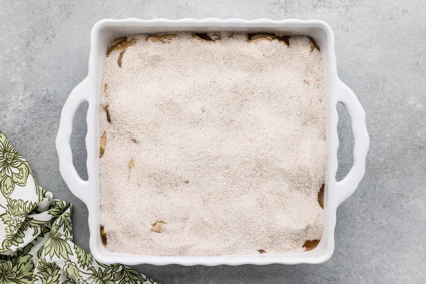 overhead photo of sugar mixture on top of cobbler batter in a dish