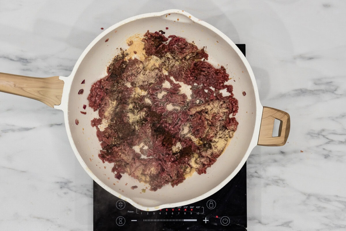 seasonings added on top of ground sirloin in a skillet