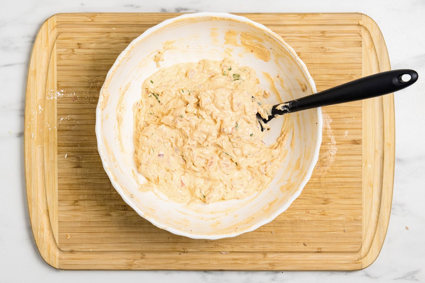 Rubber spatula in a bowl of mixed shrimp dip