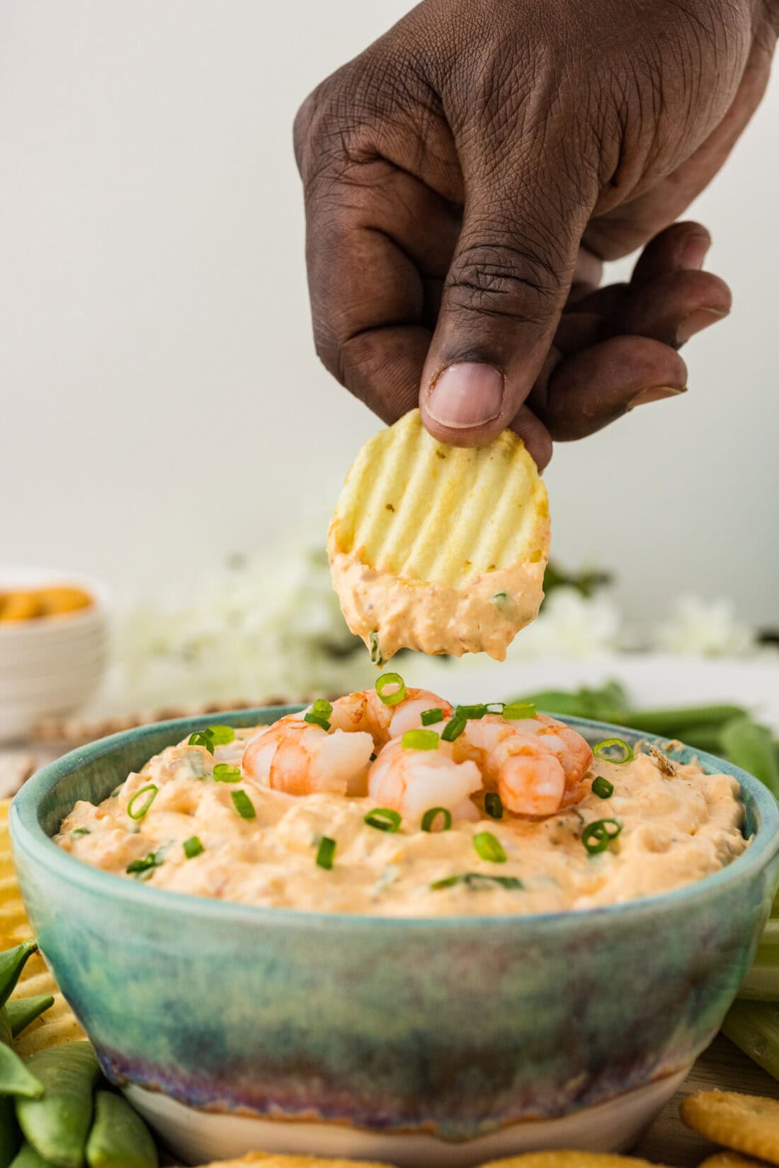Hand holding a chip with dip on it