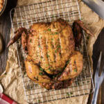 Close up photo of a Smoked Chicken resting on a wire rack