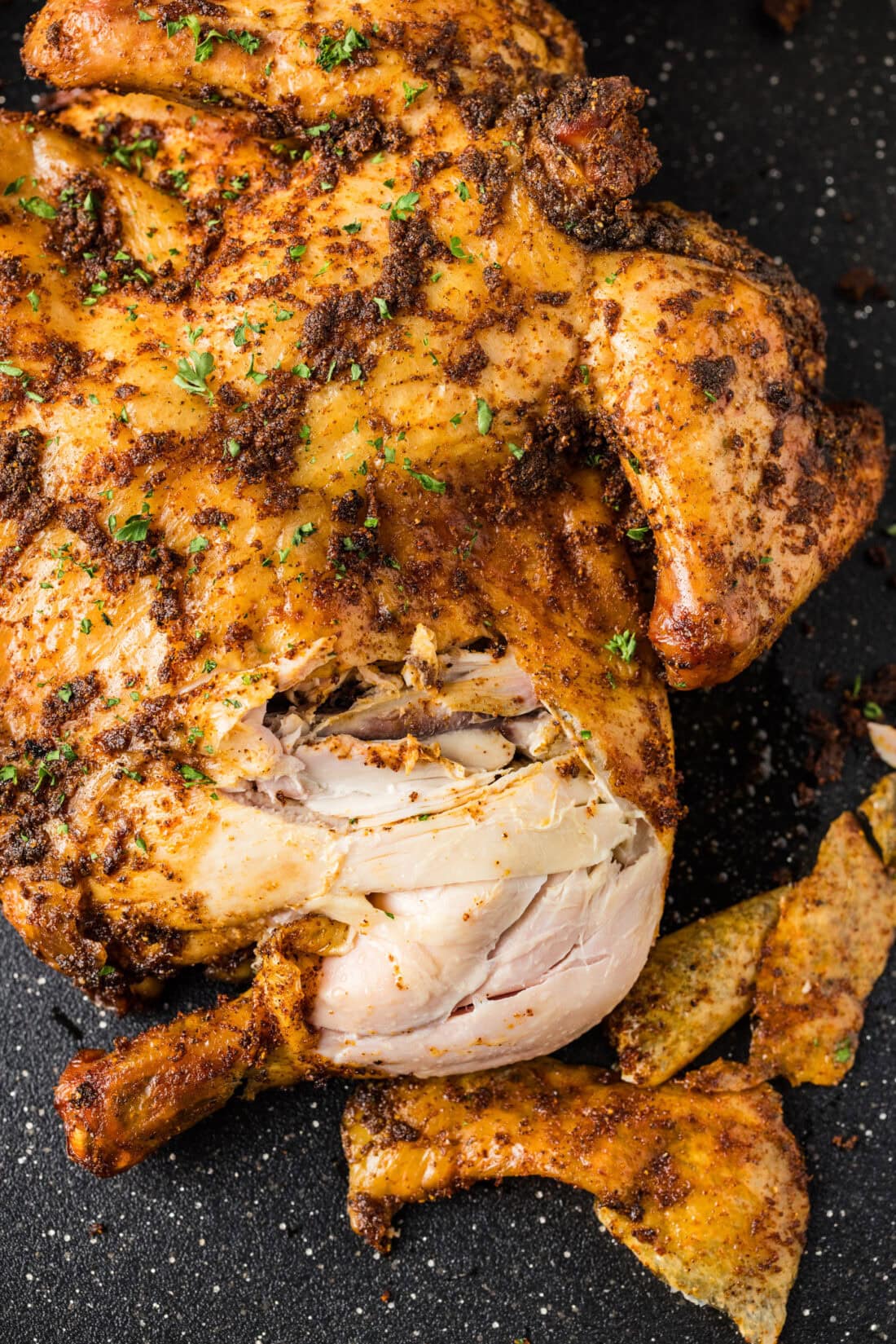 Close up photo of a Smoked Spatchcock Chicken cut apart