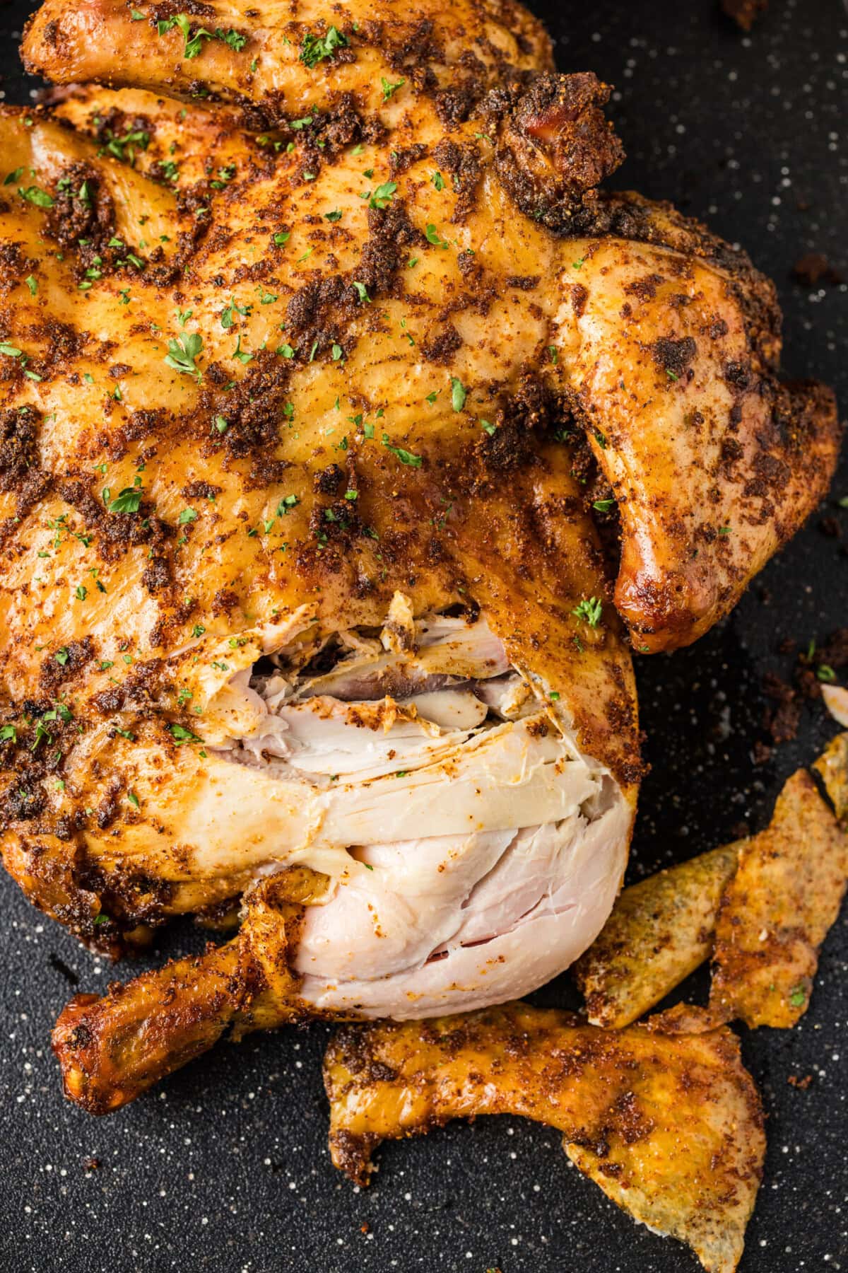 Close up photo of a Smoked Spatchcock Chicken cut apart