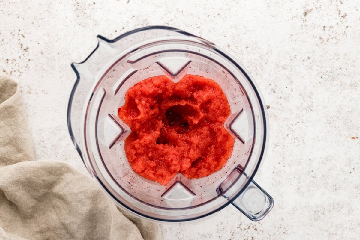 overhead of frozen strawberry margarita slush in a blender