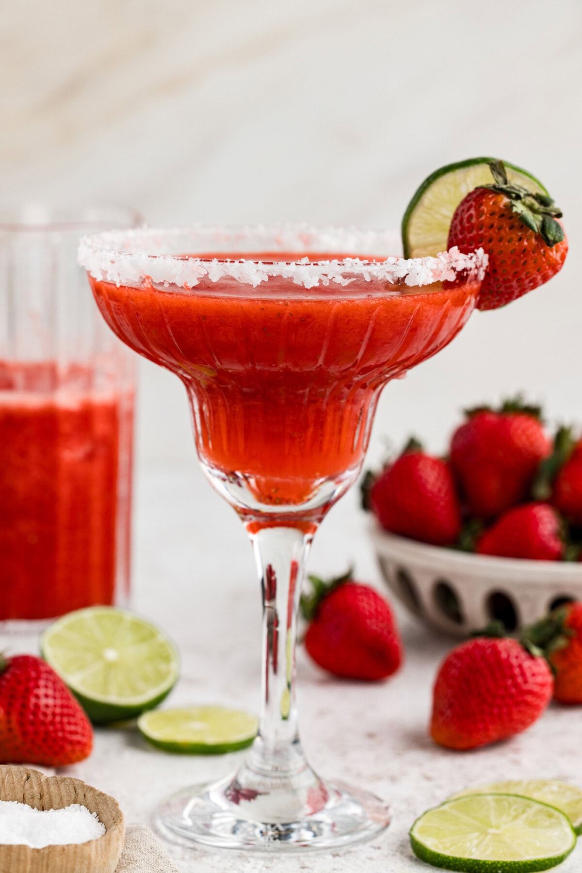 Side view of a Strawberry Margarita garnished with a lime wheel and strawberry