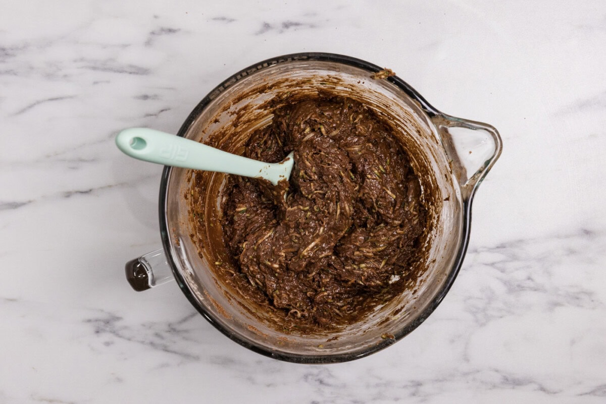 Rubber spatula in a bowl with zucchini brownie batter
