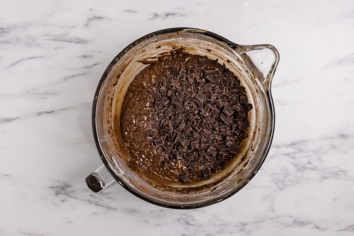 chopped chocolate added to bowl with brownie batter
