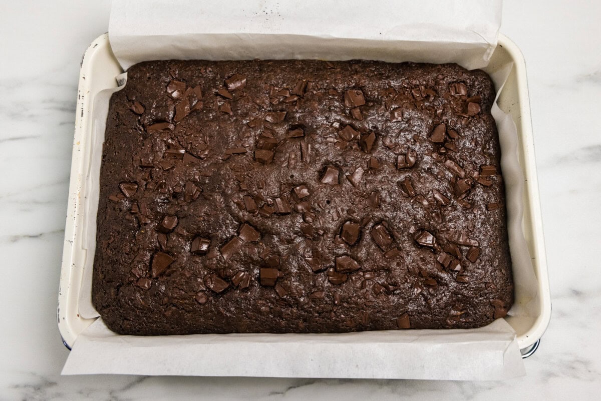 pan of baked zucchini brownies with parchment paper over the side