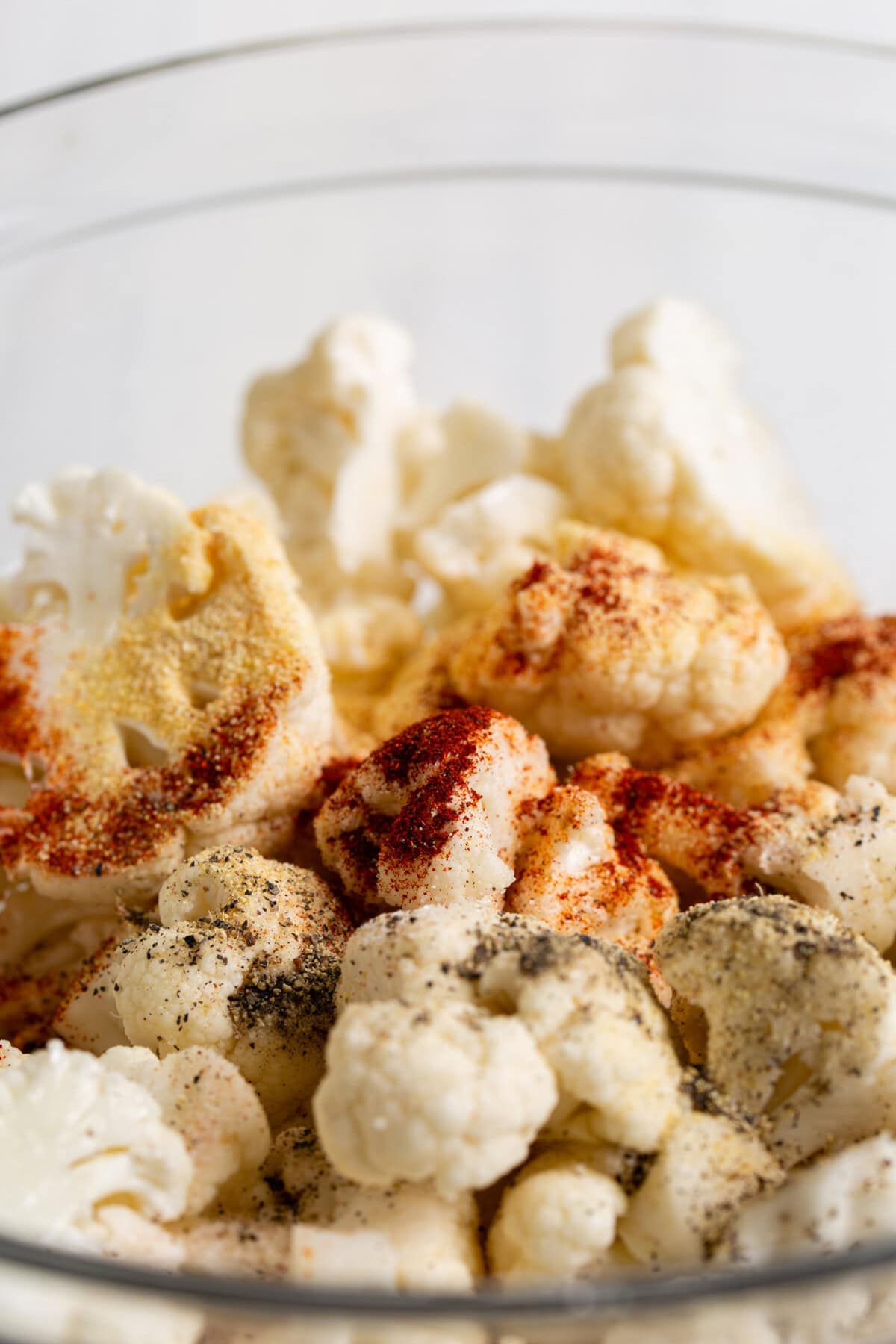 Seasonings sprinkled over a bowl of cauliflower