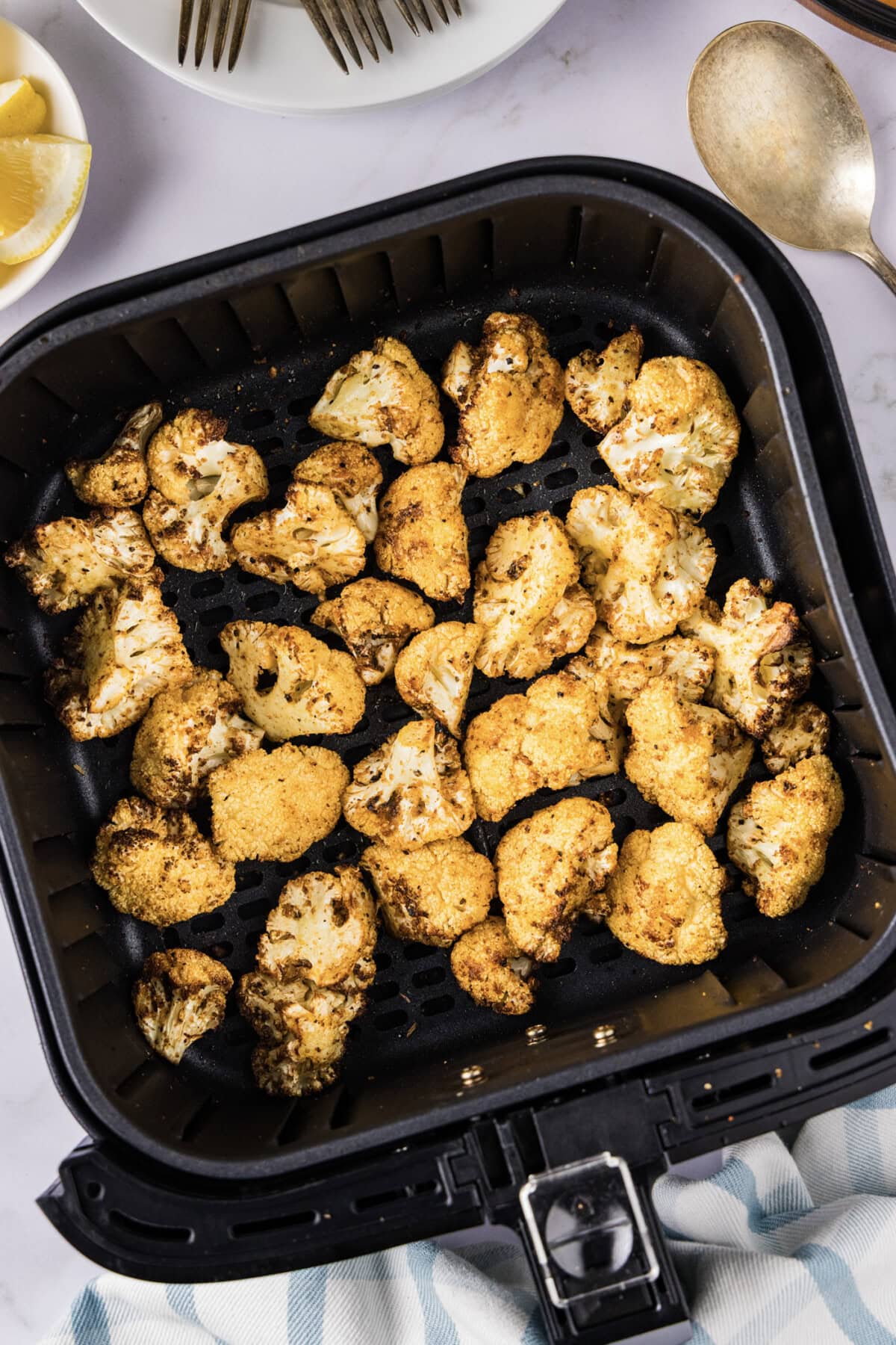 Air Fryer Cauliflower resting in an air fryer basket