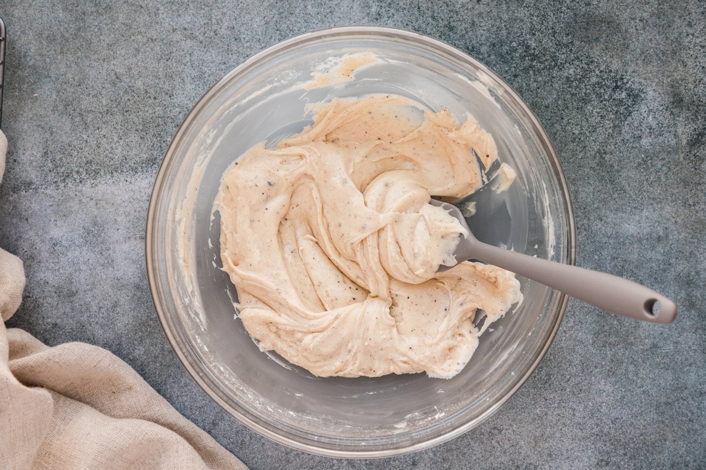 brown butter glaze in a mixing bowl with a rubber spatula