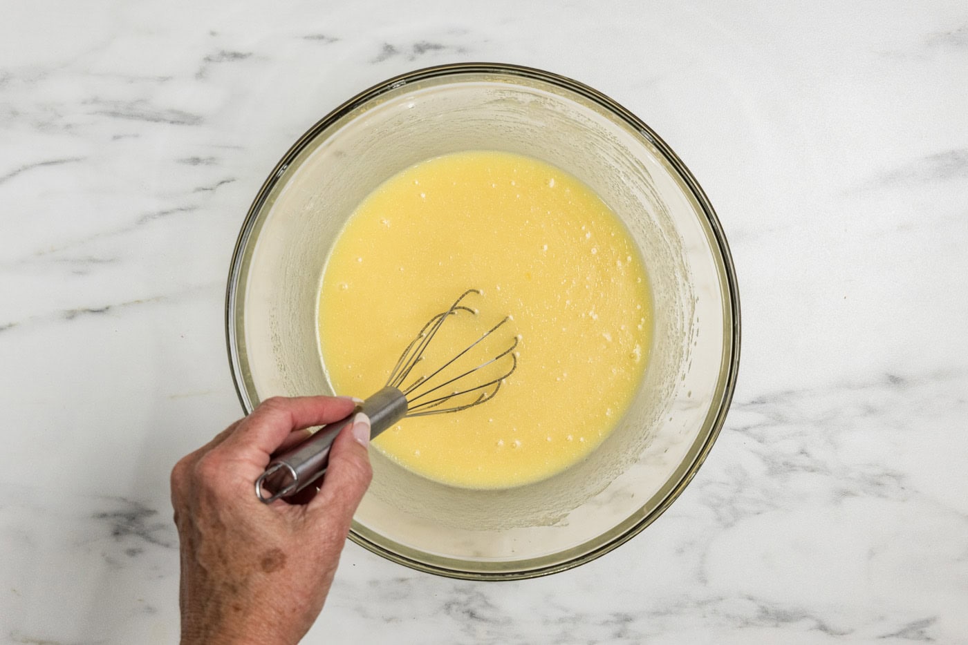 whisking wet ingredients for apple muffins in a bowl