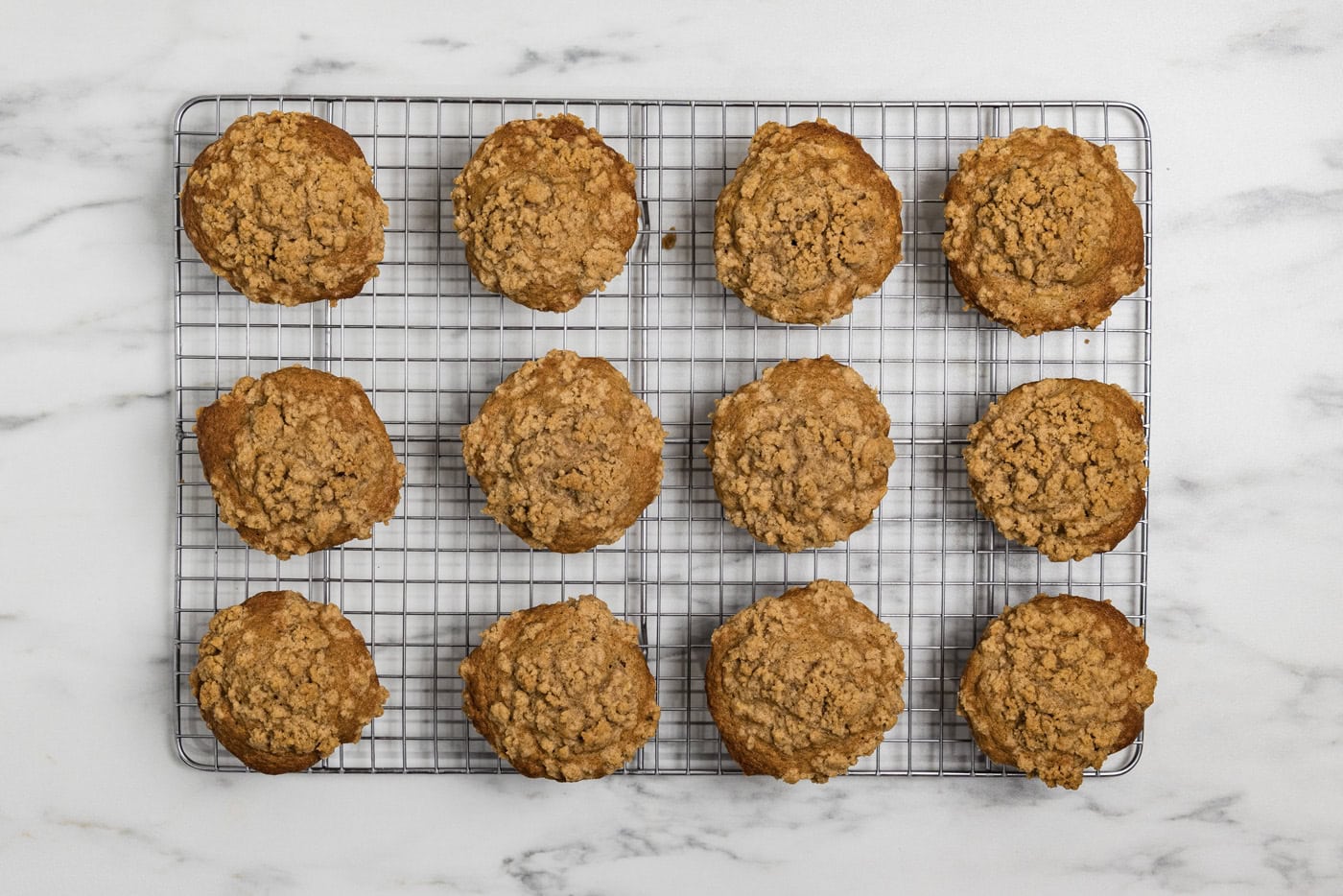 baked apple streusel muffins on a wire cooling rack