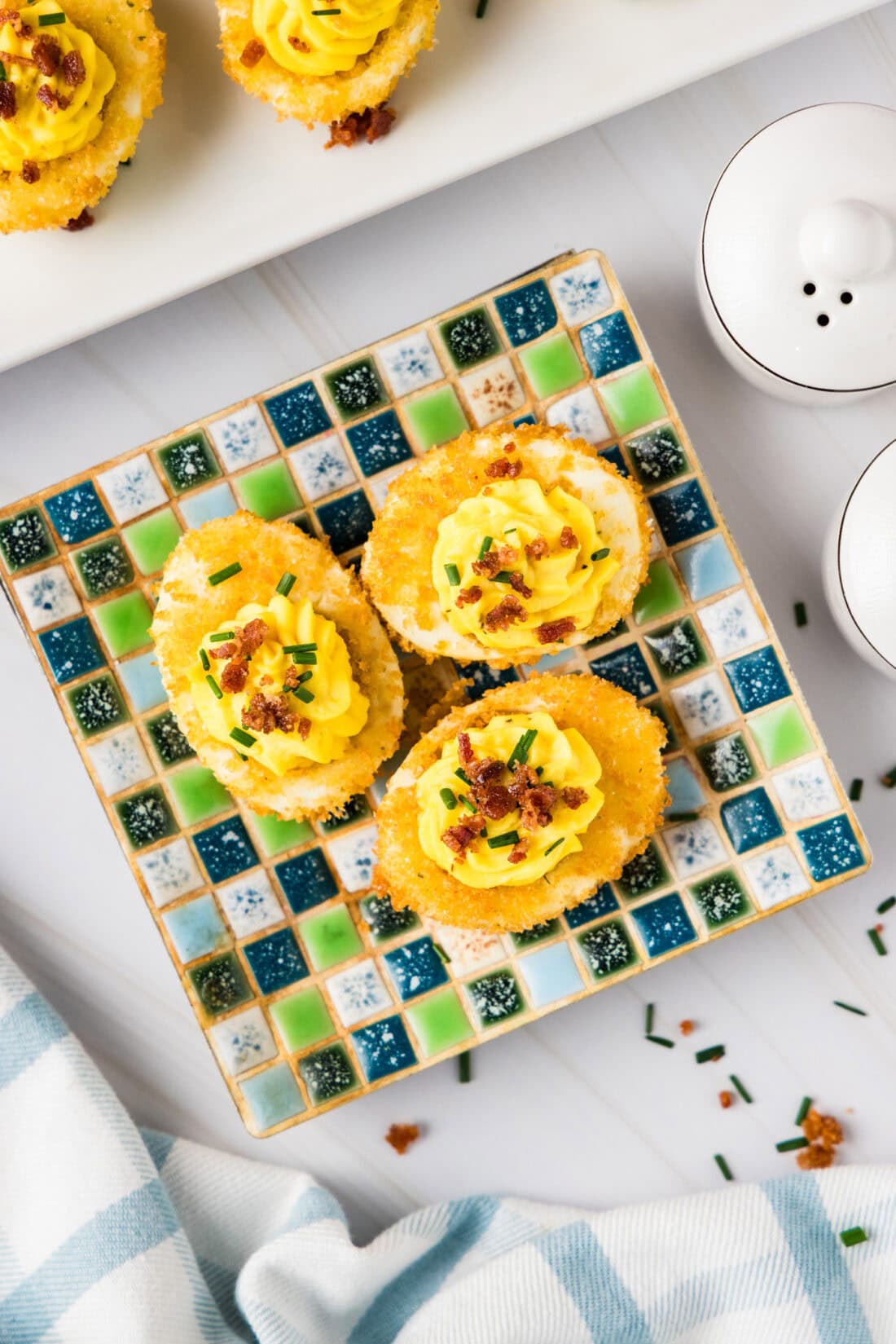 Three Fried Deviled Eggs on a square plate