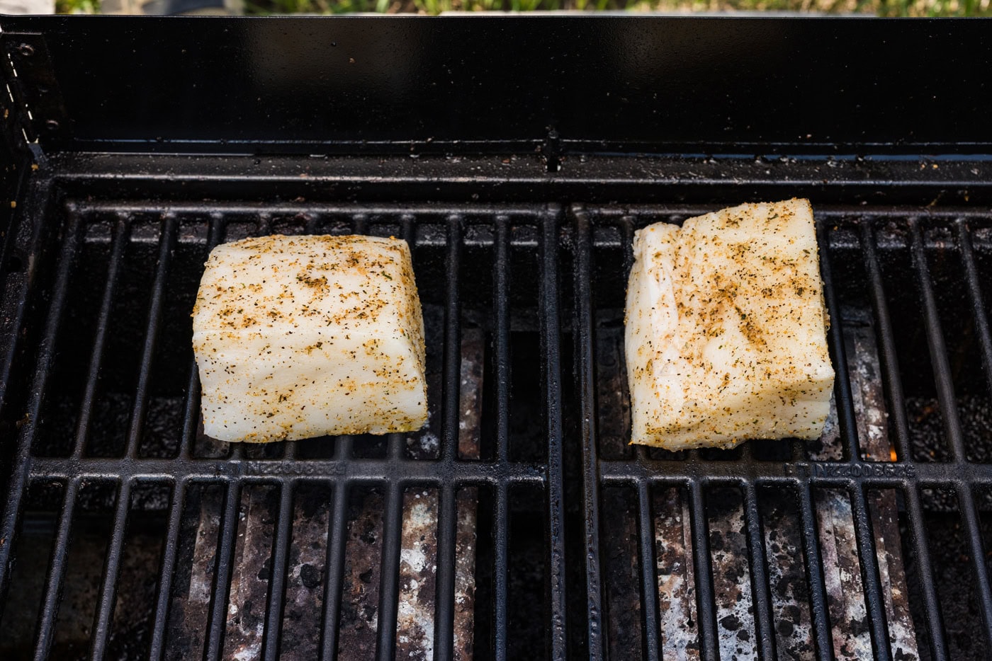 Seasoned chilean sea bass filets on hot grill grates
