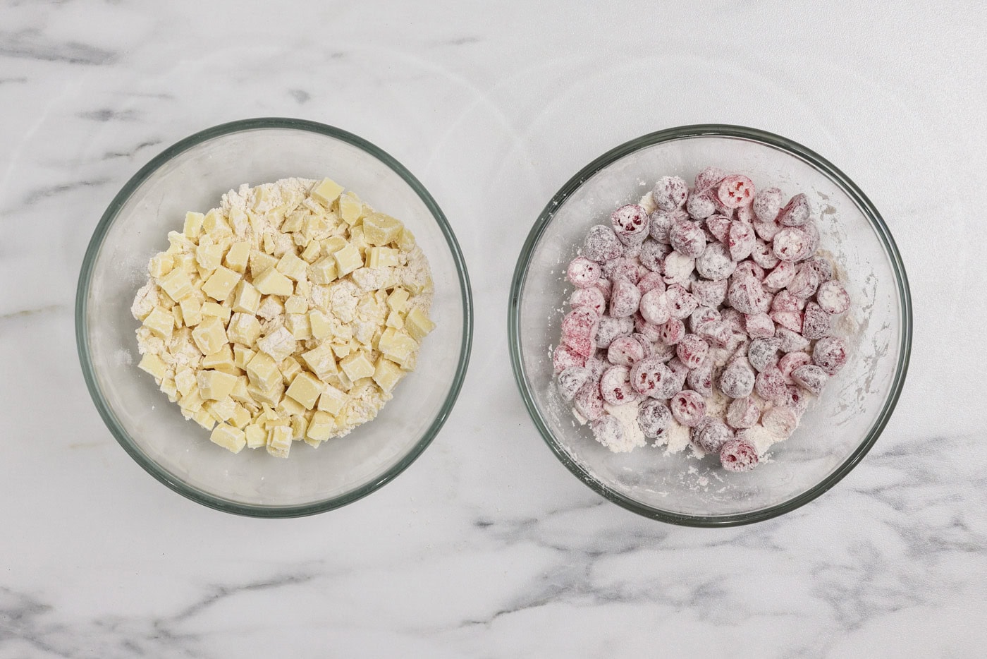 frozen cranberry and chopped chocolate coated in flour mixture in separate bowls