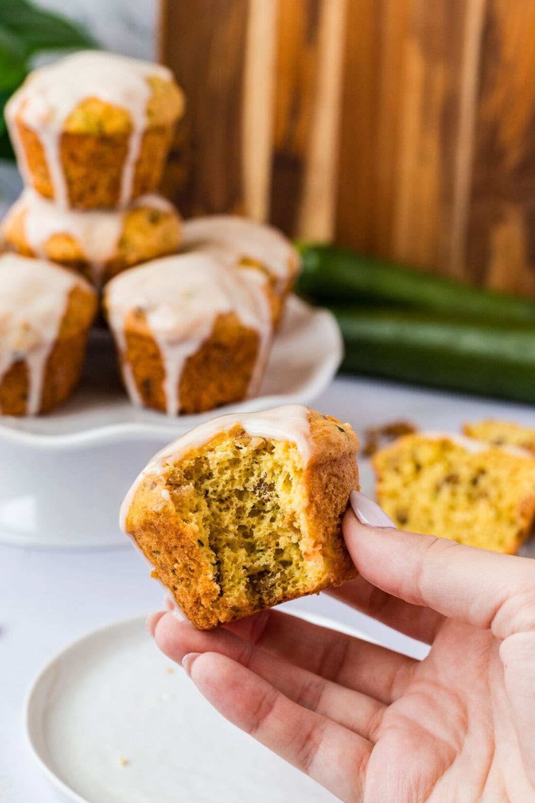 Hand holding a Shortcut Zucchini Muffin with a bite taken out