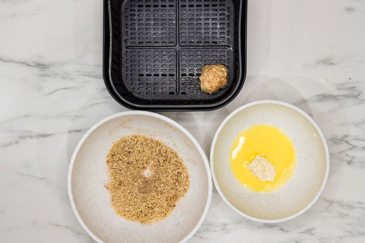 panko coated cauliflower floret in an air fryer basket
