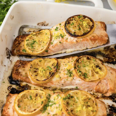 Baked Lemon Salmon filet being lifted out of the pan
