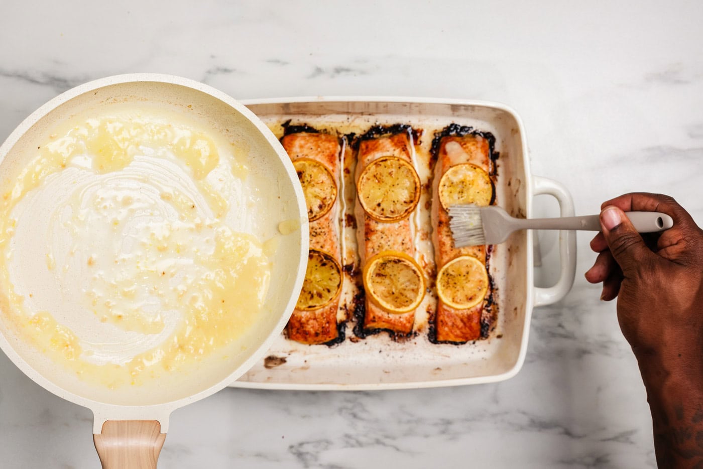brushing cooked lemon salmon filets with lemon butter sauce