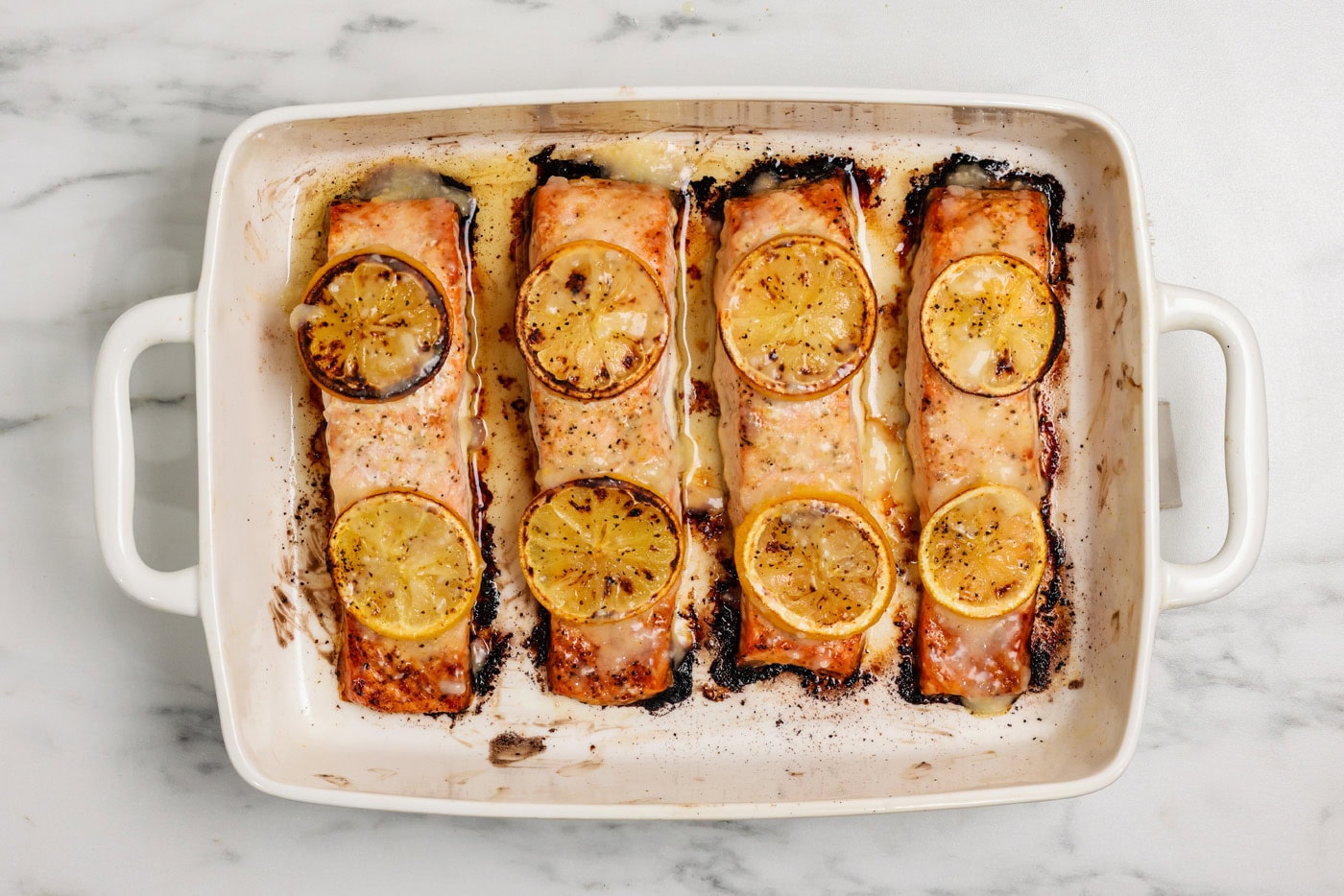 overhead shot of baked lemon salmon in a baking sheet